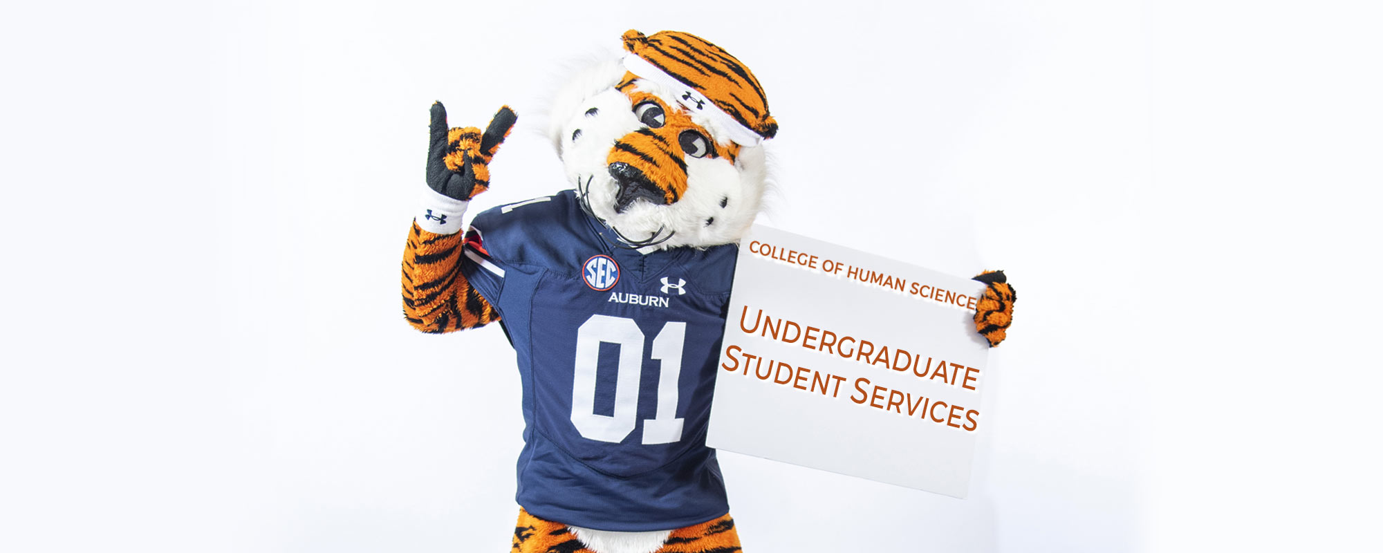 Aubie holding a sign that reads undergraduate student services.