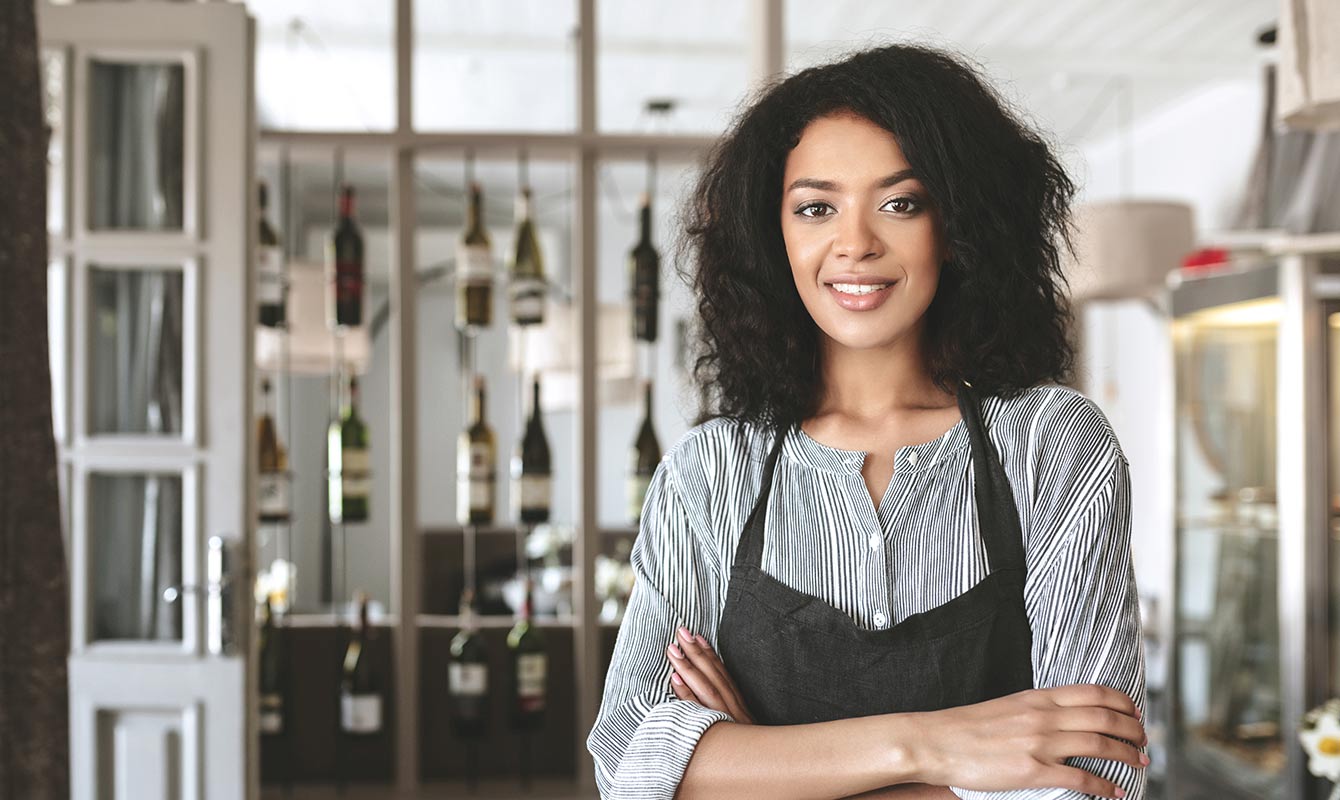 Student in an apron with arms folded.