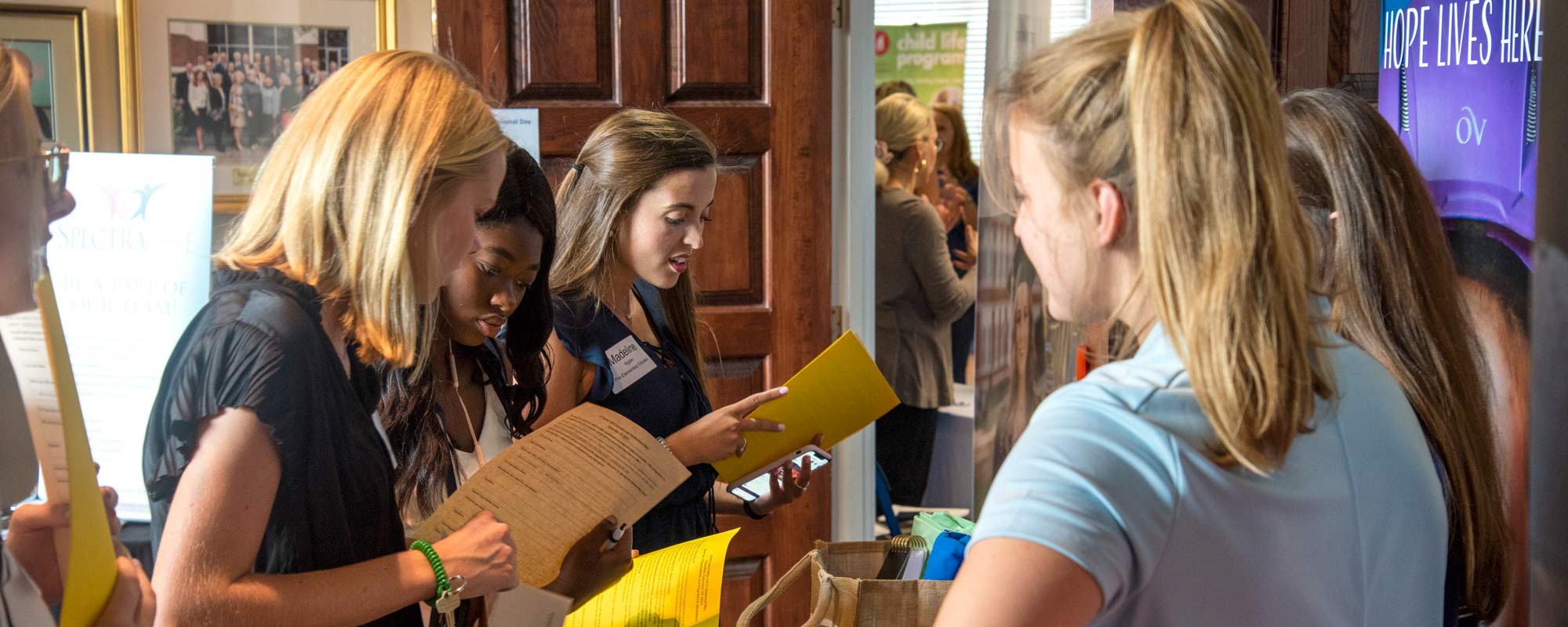 Photo of students reading material at an internship fair.