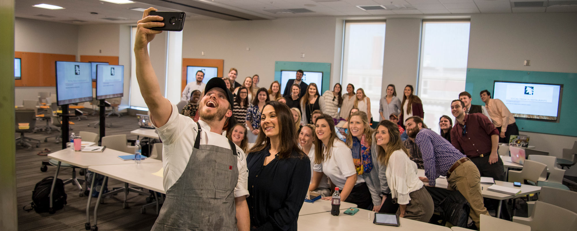 Chef David Bancroft talking a selfie with Alecia Douglas' Ph.D. senior lecture series class.