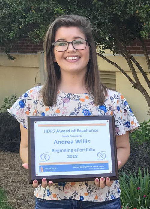 Andree holding a plaque of her Beginning ePortfolio award.