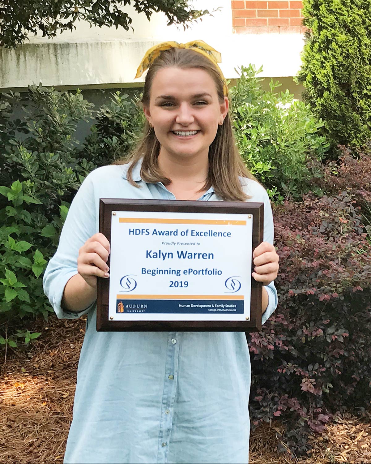 Kalyn holding a plaque of her Beginning ePortfolio award.