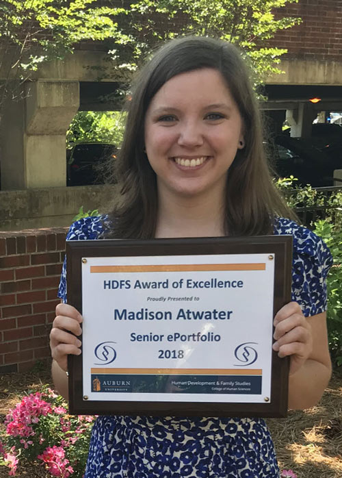 Madison holding a plaque of her Senior ePortfolio award.