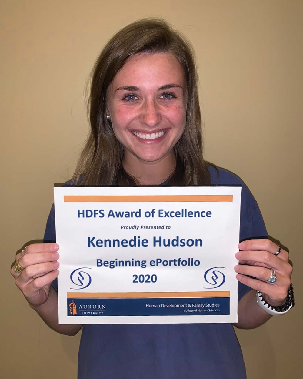 Kennedie holding a plaque of her Beginning ePortfolio award.